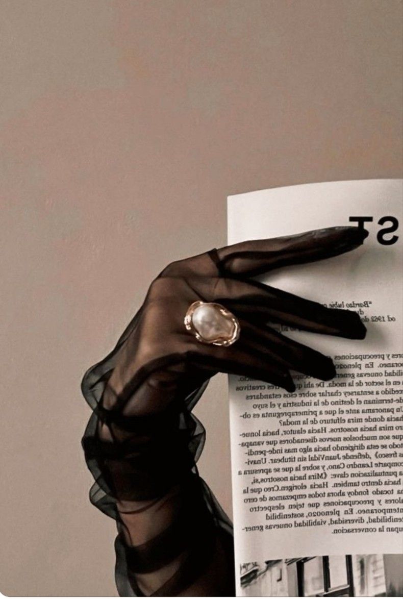 A sheer black glove with a pearl ring
